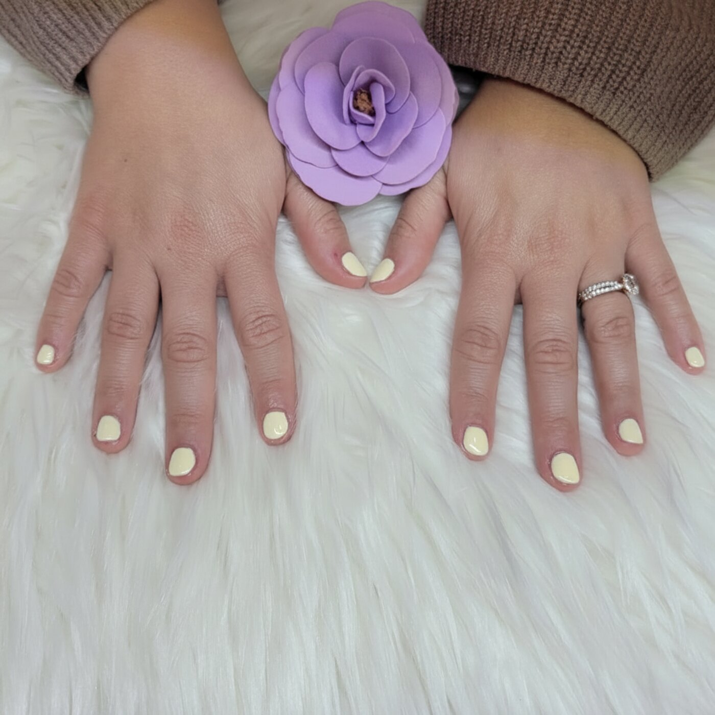 Soft pastel yellow gel manicure with lavender rose accent